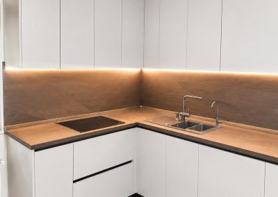 Bucătărie albă modernă cu blat și contrablat din nuc, iluminare LED, la comandă