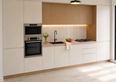 Bucatarie bej mata fara manere, cu nisa si corpuri suspendate bej-maro si coloana cu cuptoare incorporate