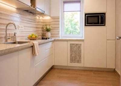 Bucatarie liniara ingusta cu fronturi taupe, blat crem, rafturi deschise si cuptor cu microunde incorporat