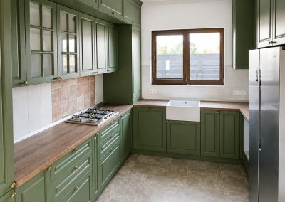 Bucătărie verde clasică cu chiuvetă farmhouse și blat din lemn masiv
